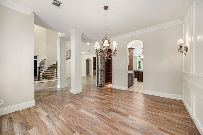 Formal dining room features a wine cellar, elegant molding, and mill work. | Image 15