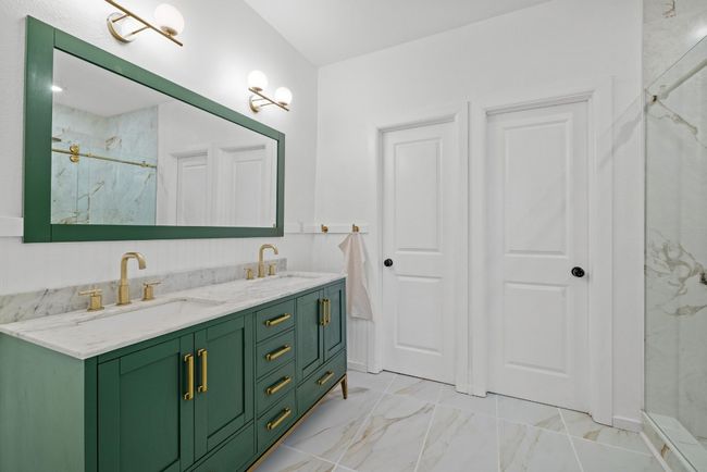 Modern primary bathroom with green cabinets and double vanity | Image 14