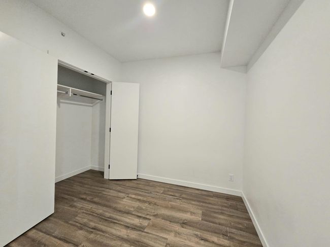 Unfurnished bedroom featuring baseboards, a closet, and dark wood finished floors | Image 12