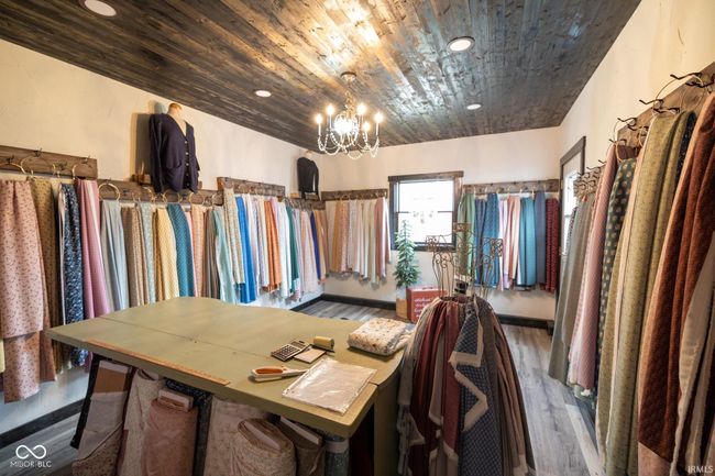 spacious closet with a chandelier and wood finished floors | Image 13