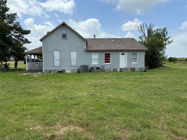 Rear view of property with a shingled roof and a yard | Image 6