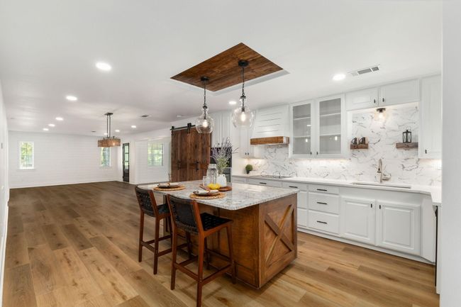 Luxurious custom kitchen featuring elegant granite countertops, soft-close cabinetry, and a spacious island for culinary creativity. | Image 12