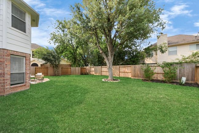 Another view of the backyard, featuring a beautiful tall tree that offers the perfect amount of shade. | Image 43
