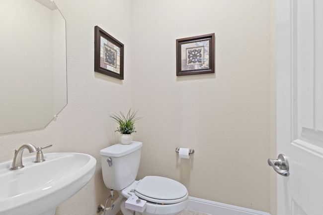 Half bathroom with a sink, toilet, and baseboards | Image 33