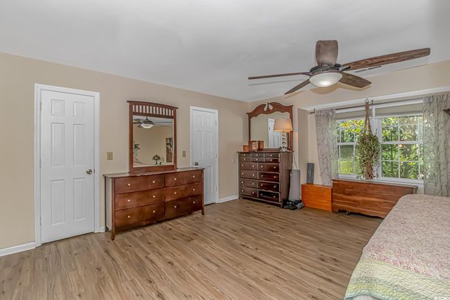 Bedroom with light wood-style flooring and a ceiling fan | Image 15