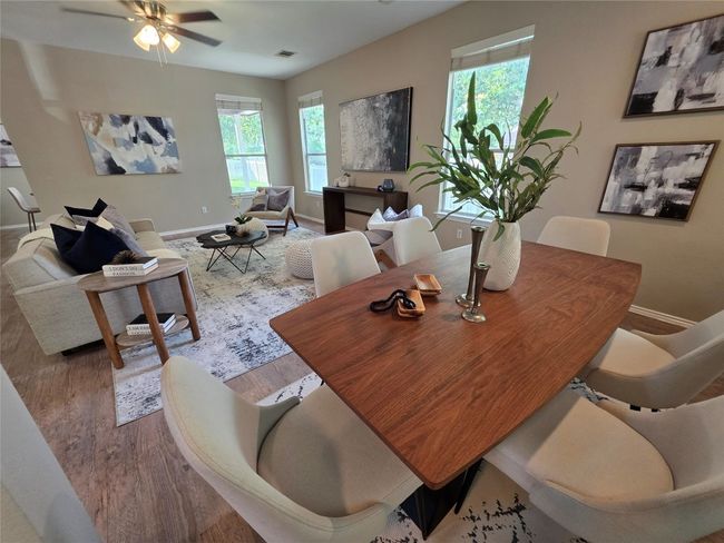 Dining space featuring healthy amount of natural light, wood look floors, and a ceiling fan | Image 4