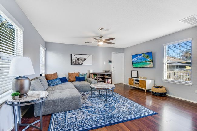 Living room with wood finished floors, plenty of natural light, and ceiling fan | Image 5