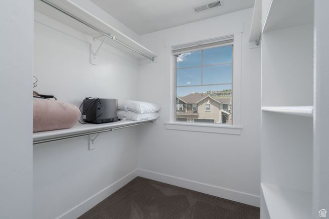 Spacious closet featuring dark colored carpet | Image 29
