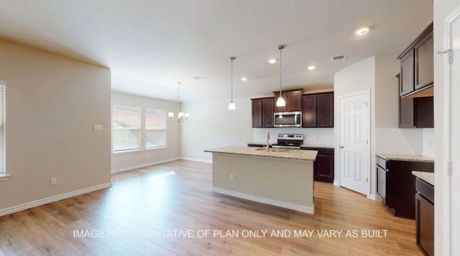 Kitchen featuring stainless steel appliances, a chandelier, dark brown cabinetry, light wood finished floors, and recessed lighting | Image 5