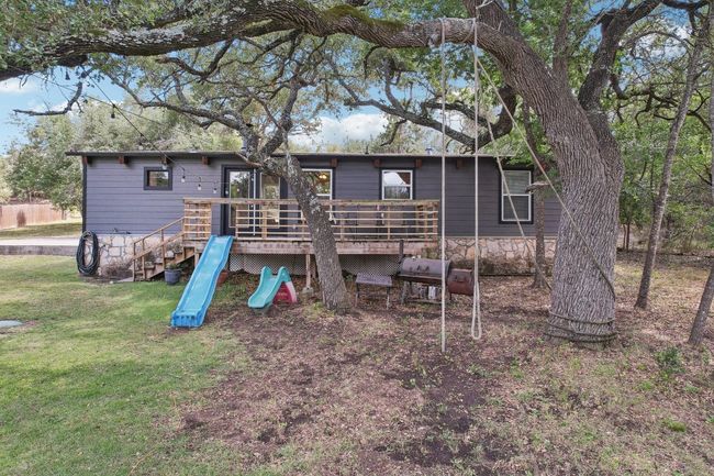 Rear view of property with a deck, a lawn, and a playground | Image 31
