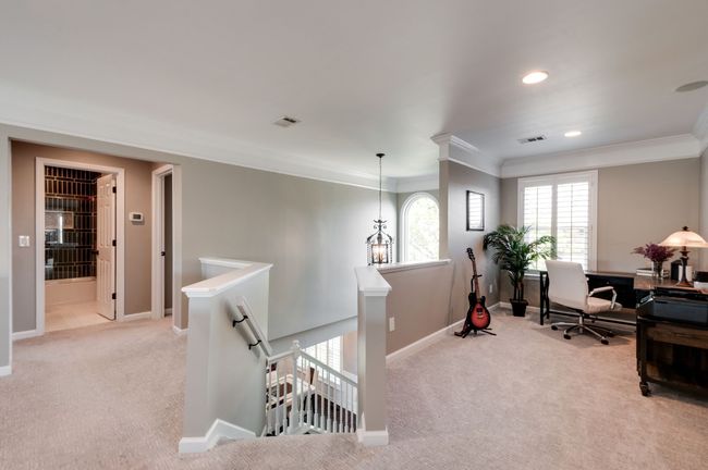 As you go up the stairs (new wood treads were installed on the stairs) you are greeted with a generous loft space that can be used as a home office or a home gym. This space has beautiful crown molding and newer carpet and pad. | Image 31