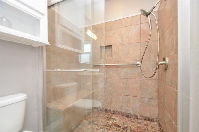 Primary bathroom with spacious walk in shower with bench and shampoo niche | Image 15