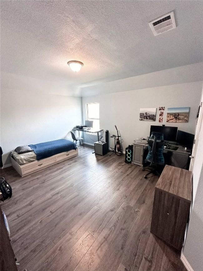 Upstairs bedroom with a textured ceiling and dark wood-type flooring | Image 20