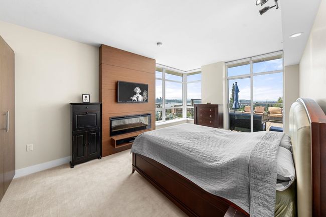Bedroom featuring light carpet, a fireplace, access to outside, and recessed lighting | Image 16