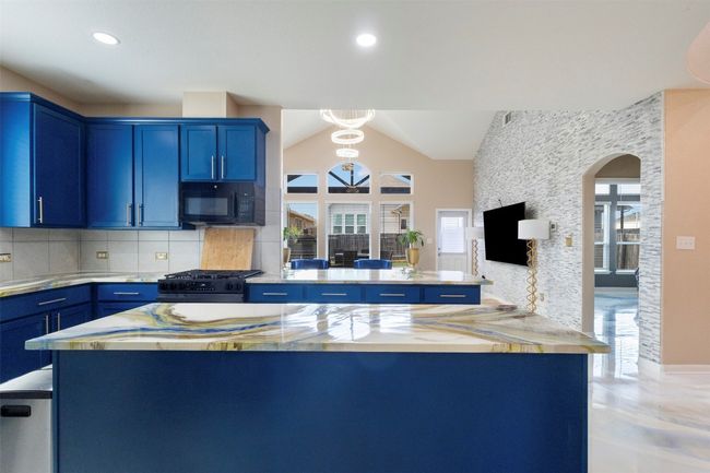 Kitchen with blue cabinets, black appliances, vaulted ceiling, and recessed lighting | Image 8
