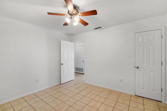 Empty room with ceiling fan and light tile patterned flooring | Image 21