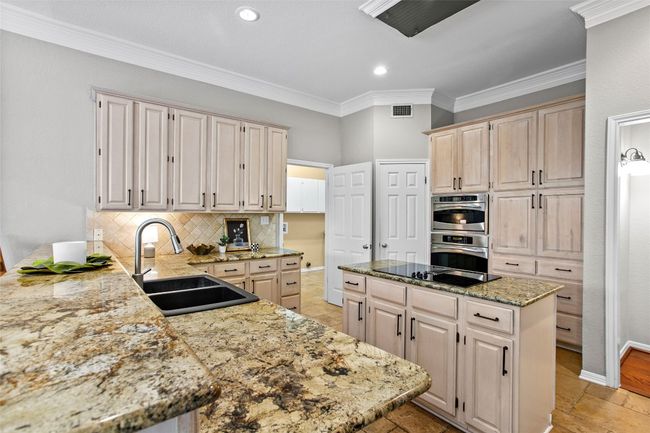 The kitchen features recent stainless steel appliances including a double oven and warming drawer | Image 10