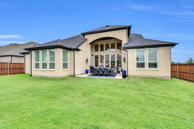 Rear view of property featuring a fenced backyard, brick siding, a shingled roof, and a patio area | Image 38
