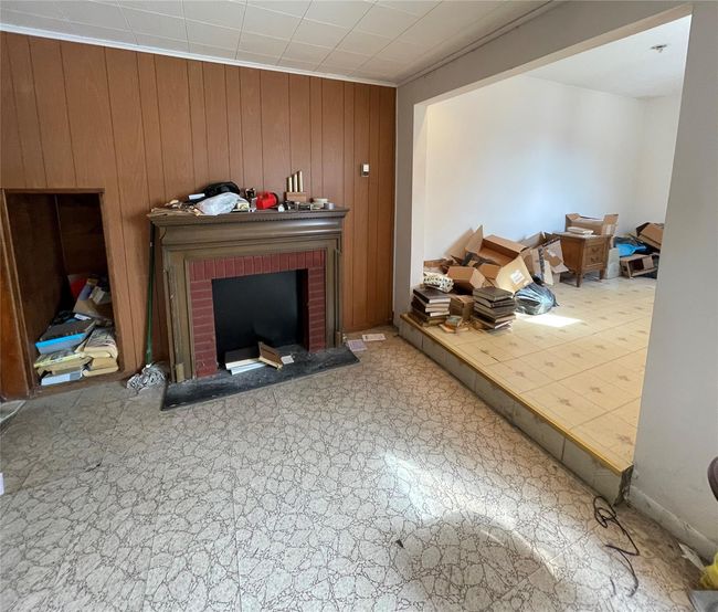Living area with wooden walls and a brick fireplace | Image 7