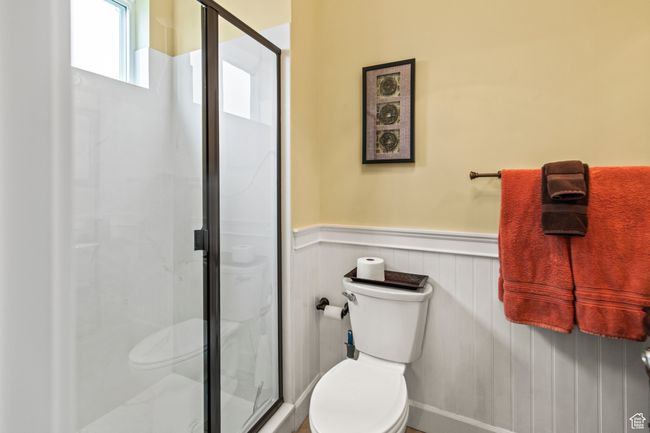 Bathroom featuring a shower with door and toilet | Image 58