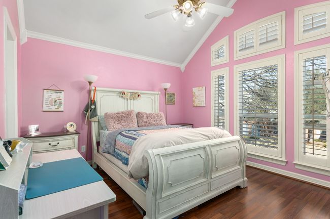 Bedroom featuring wood-style floors, vaulted ceiling, ornamental molding, and ceiling fan | Image 24