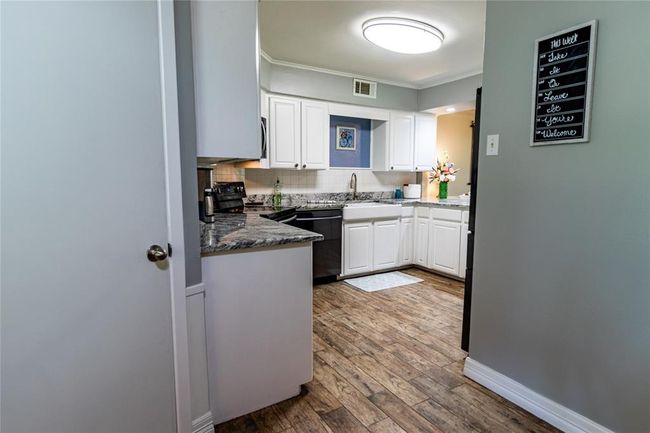 View of kitchen from dining area. Door to the left is to the utility room. | Image 36