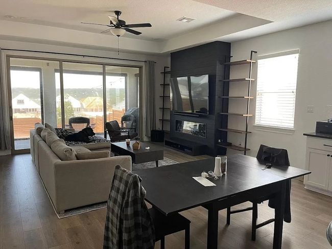 Living room with light wood-style flooring and ceiling fan | Image 5