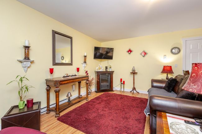 Living room with a fireplace and wood finished floors | Image 22