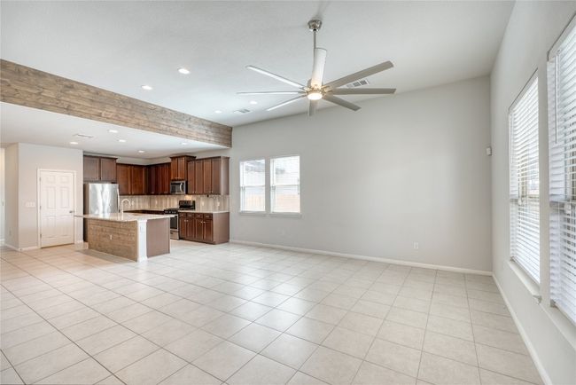 Kitchen with light tile patterned flooring, ceiling fan, open floor plan, appliances with stainless steel finishes, and tasteful backsplash | Image 12