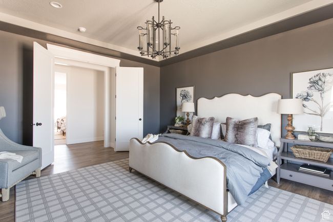 Bedroom featuring an inviting chandelier and hardwood / wood-style flooring | Image 8