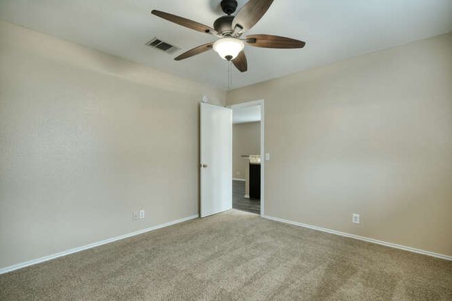 Spare room with a ceiling fan, carpet, and baseboards | Image 7