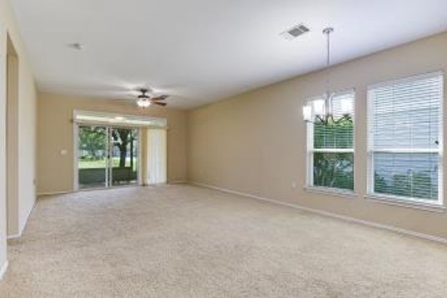 Carpeted spare room featuring ceiling fan and a chandelier | Image 5