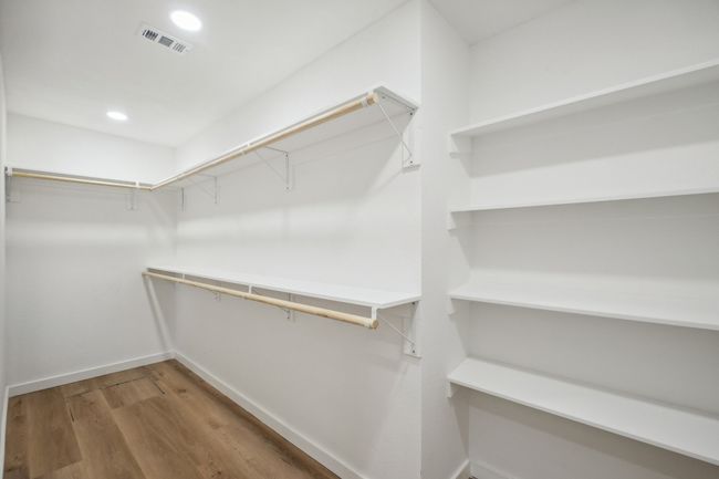 Primary Walk in closet with wood finished floors | Image 23