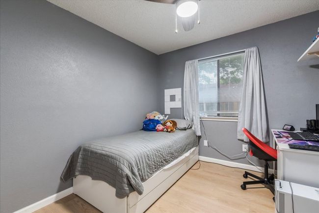 Bedroom featuring baseboards, light wood-style flooring, ceiling fan, and a textured ceiling | Image 16