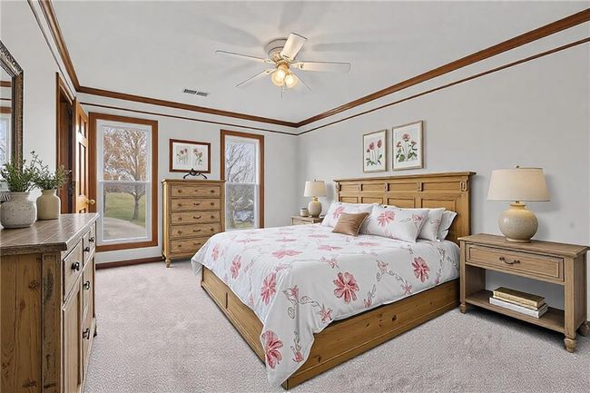 Bedroom with light carpet, visible vents, a ceiling fan, and ornamental molding | Image 34