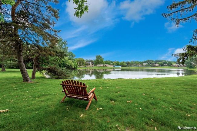 View of home's community with a water view, a lawn, and view of scattered trees | Image 37