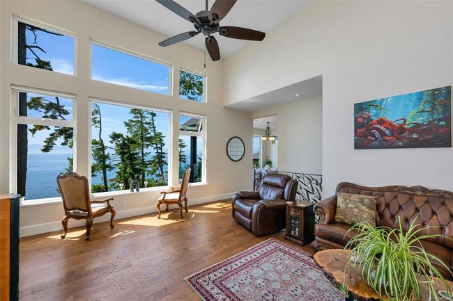 Living area featuring wood finished floors, ceiling fan, a towering ceiling, and a chandelier | Image 40