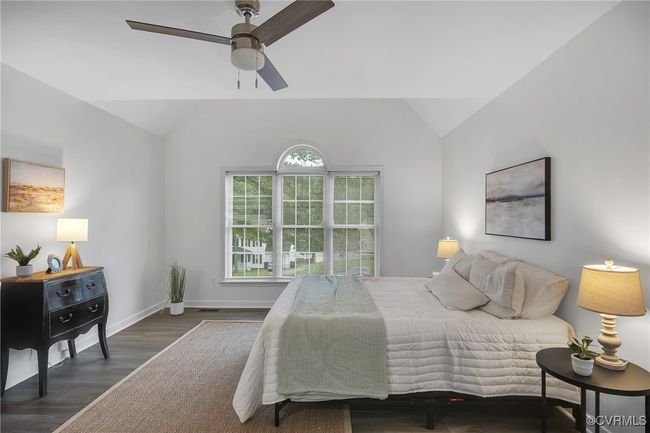 Bedroom with lofted ceiling, wood finished floors, a ceiling fan, and baseboards | Image 11