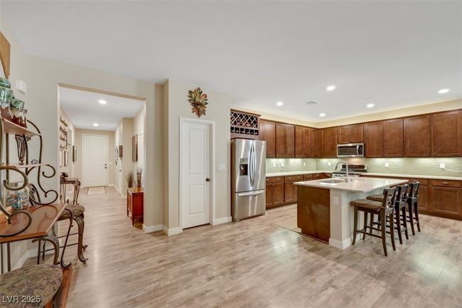 Kitchen featuring backsplash, light countertops, stainless steel appliances, and light wood-style floors | Image 14