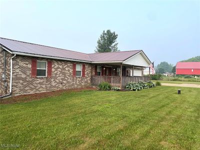 View of front of house featuring covered porch and a front yard | Image 1