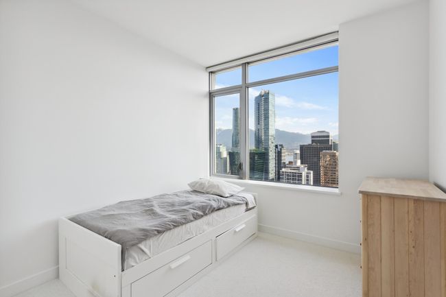 Bedroom featuring baseboards, carpet floors, and a city view | Image 19