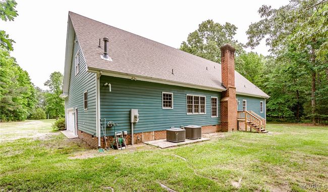 Back of property with a chimney, central air condition unit, a lawn, and a shingled roof | Image 38