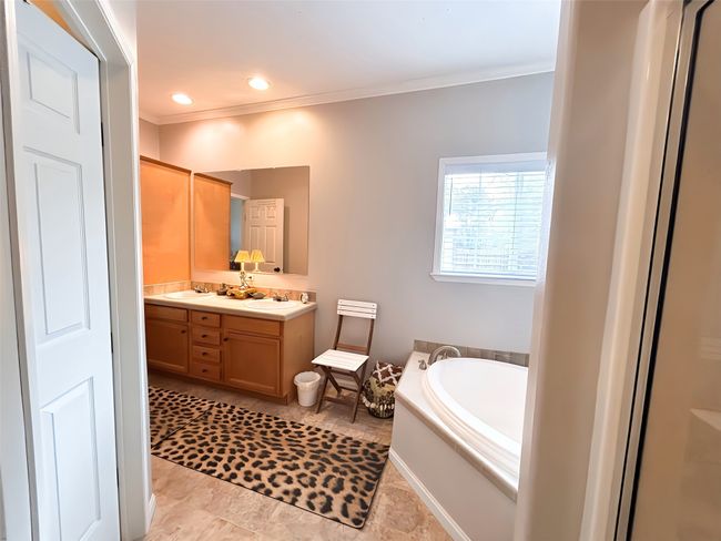 Bathroom with a sink, a garden tub, recessed lighting, ornamental molding, and double vanity | Image 9