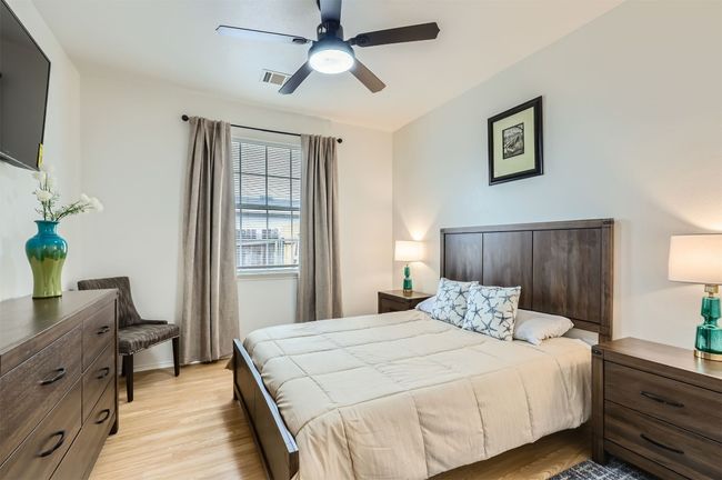 Bedroom featuring light wood finished floors and ceiling fan | Image 20