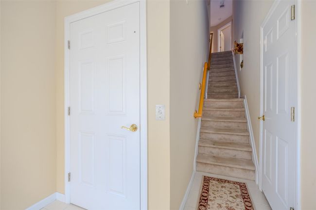 Staircase with baseboards and tile patterned floors | Image 5