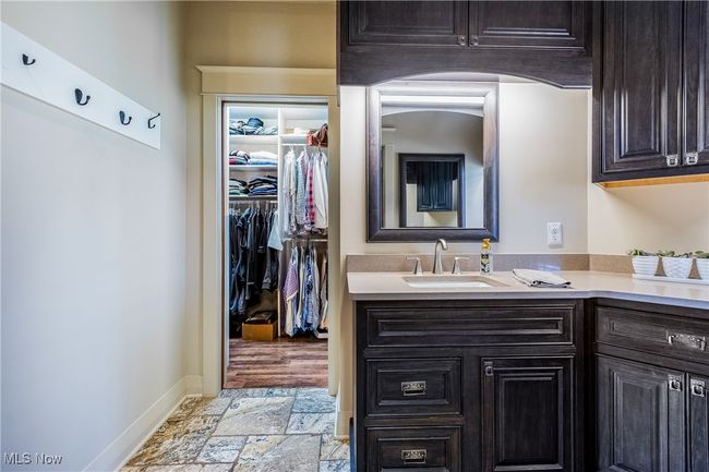 Master en-suiteBathroom with stone tile floors, a spacious closet, baseboards, and vanity | Image 29
