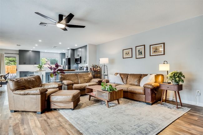 Living area with a ceiling fan, light wood-type flooring, recessed lighting, and baseboards | Image 9