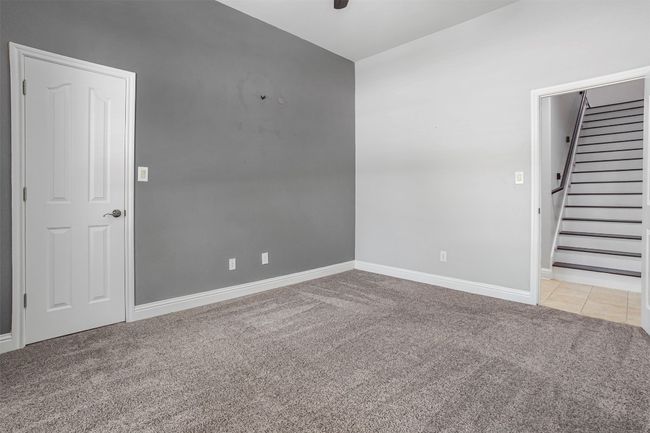 Empty room featuring light carpet, stairway, baseboards, a ceiling fan, and light tile patterned flooring | Image 21