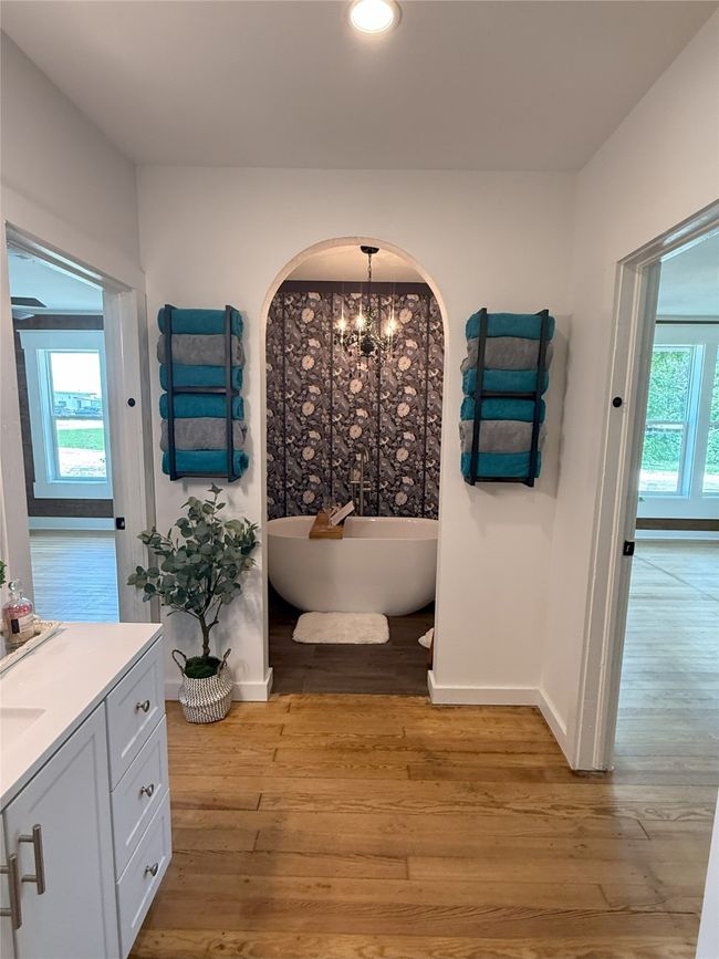 Bathroom featuring vanity, a freestanding tub, wood finished floors, a chandelier, and recessed lighting | Image 21