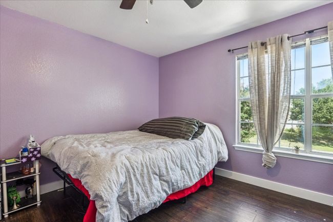 Bedroom featuring wood finished floors, baseboards, and ceiling fan | Image 25
